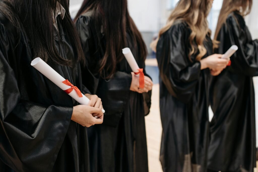pexels-photo-7942514-7942514 Graduates lined up in gowns holding diplomas at a ceremony. Capturing the essence of academic achievement.